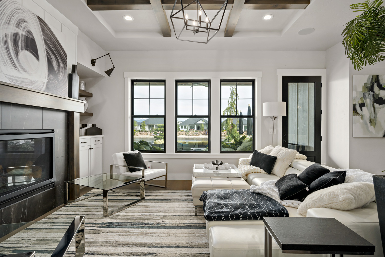 Elegant living room interior with coffered beam ceiling, modern fireplace, and black-framed windows