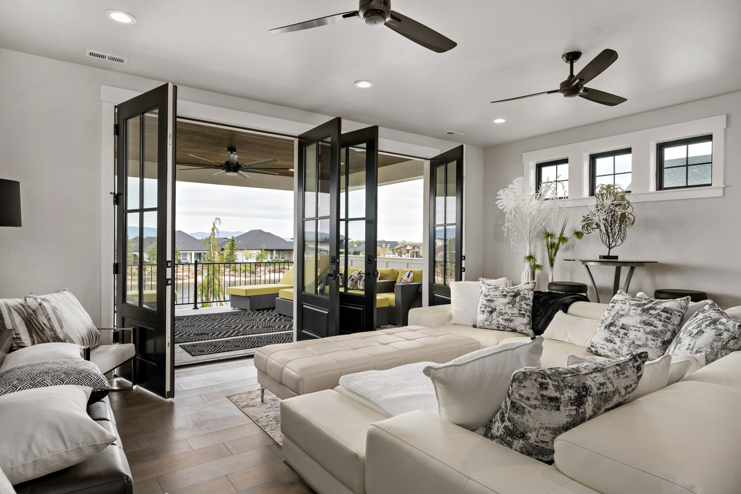 Interior living room with bifold glass doors opening to covered patio with mountain views in Boise