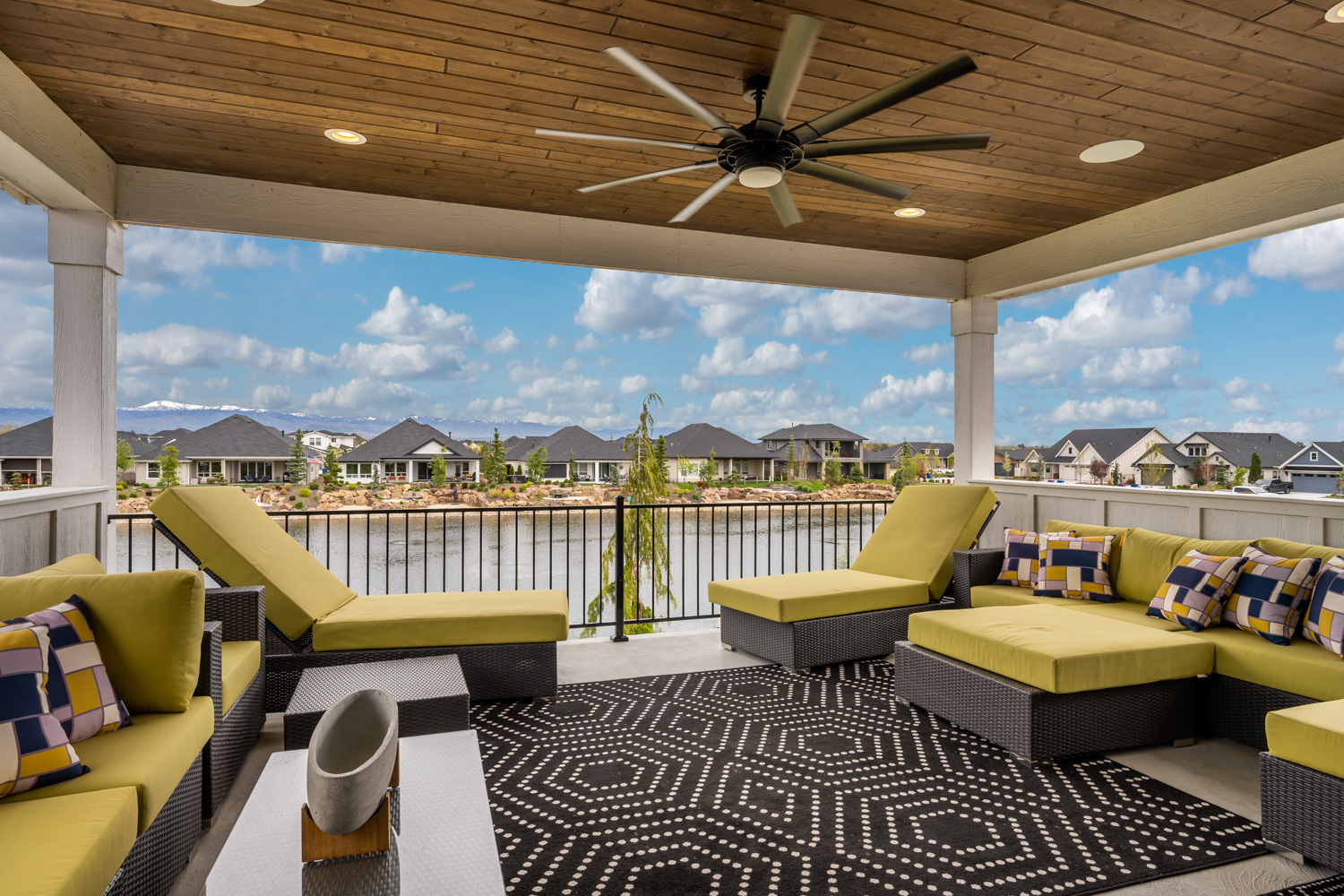 Exterior covered patio with lounge furniture, ceiling fan, and waterfront mountain views in Boise Idaho
