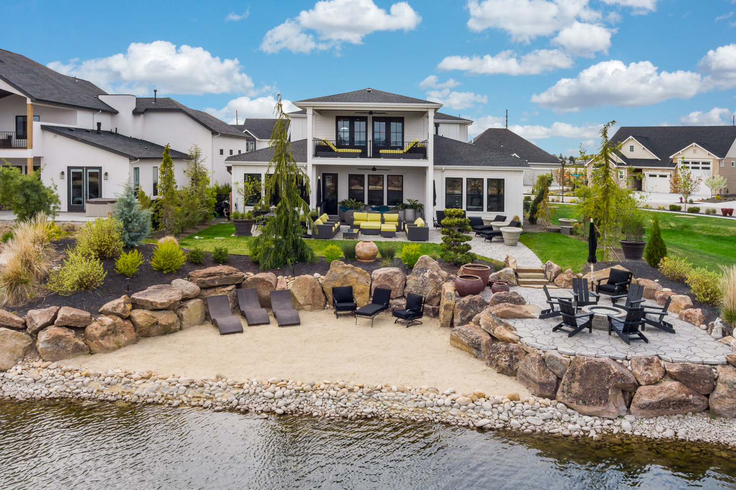 Aerial exterior view of luxury waterfront home with private beach and fire pit in Boise Idaho