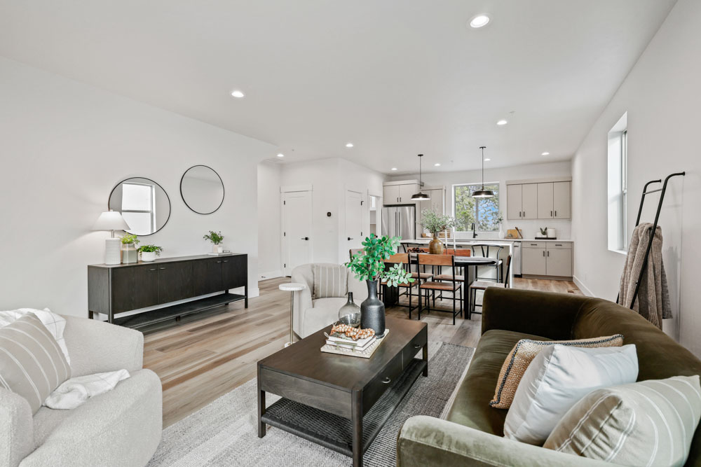 Interior open-concept living room and kitchen with modern staging and hardwood floors in Boise Idaho