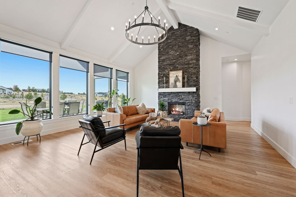 Interior living room with vaulted ceilings, stacked stone fireplace, and large windows in Boise Idaho