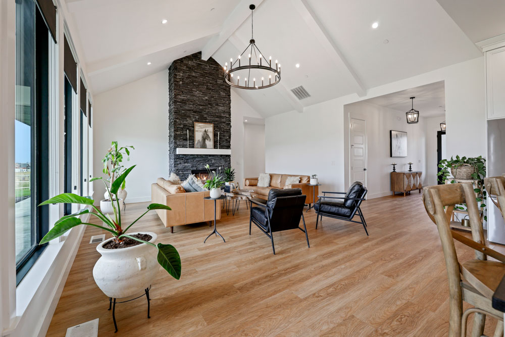 Spacious great room interior with vaulted ceiling, stacked stone fireplace, and chandelier in Boise Idaho