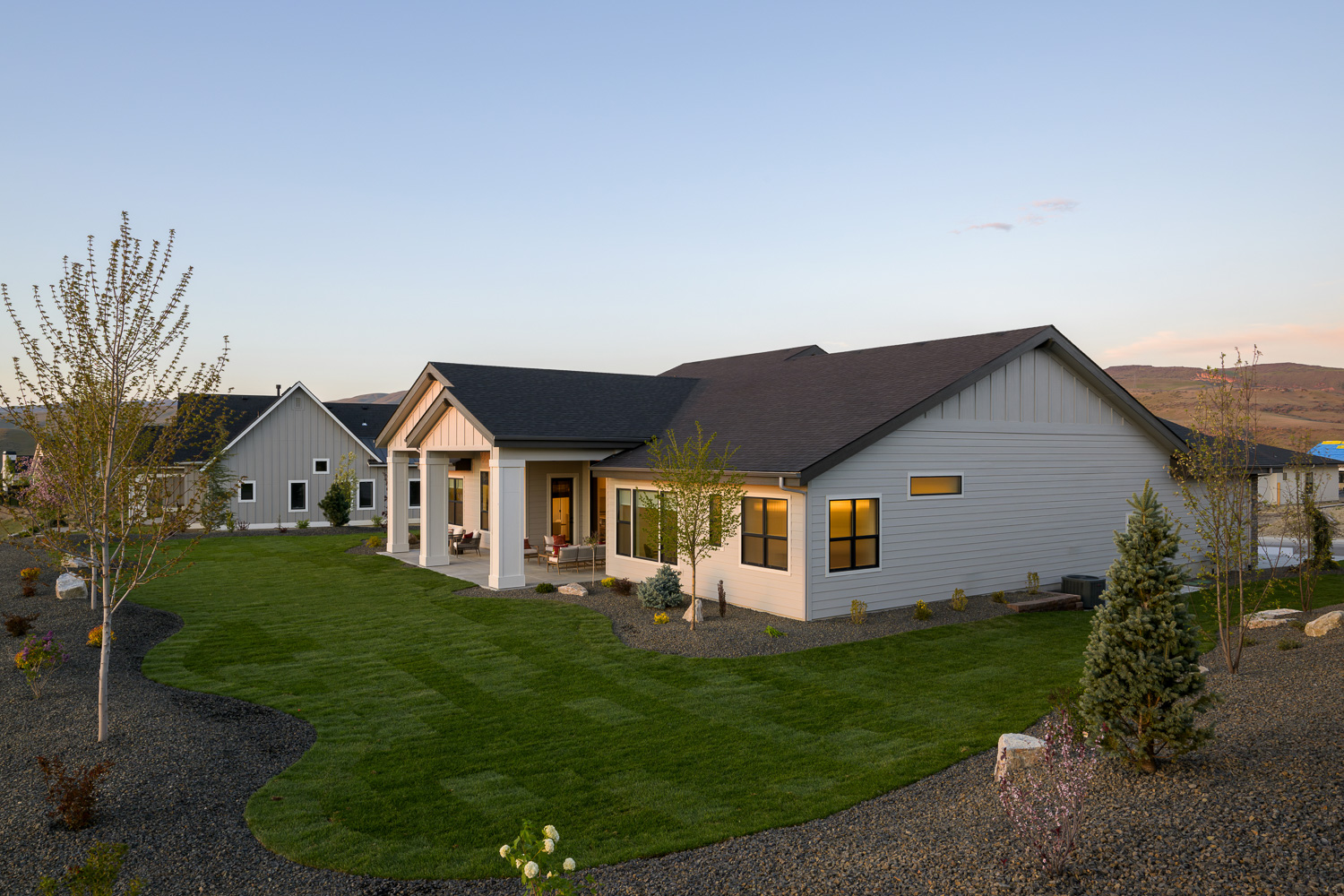 White modern farmhouse with metal roof at twilight in Bennett Valley Boise Idaho
