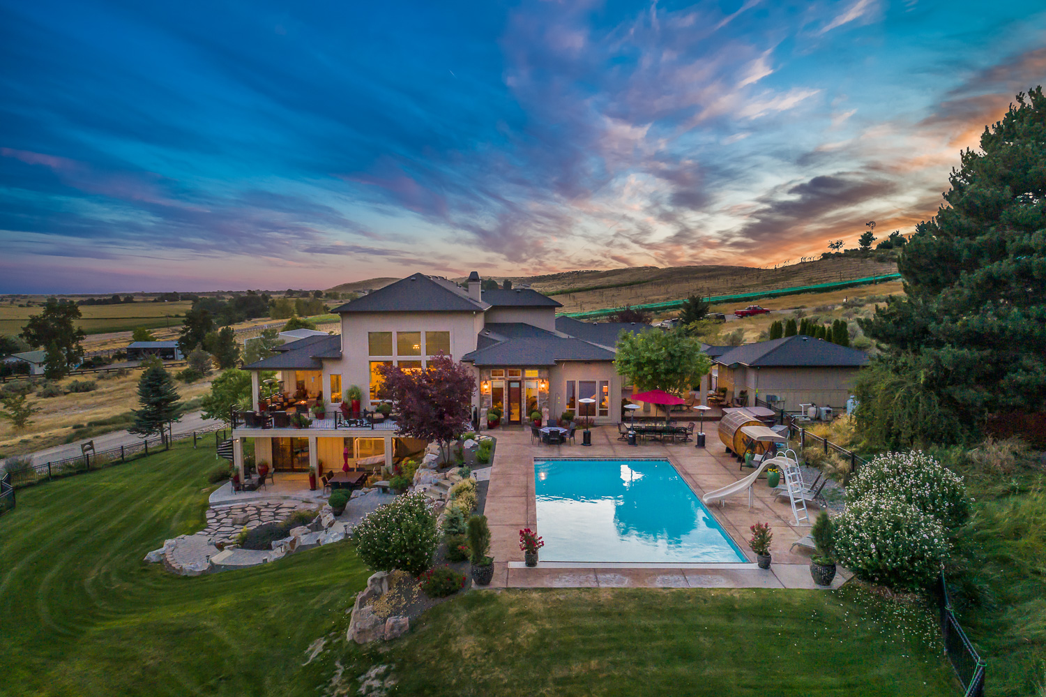 Luxury home backyard with pool and vibrant sunset sky in Boise Idaho