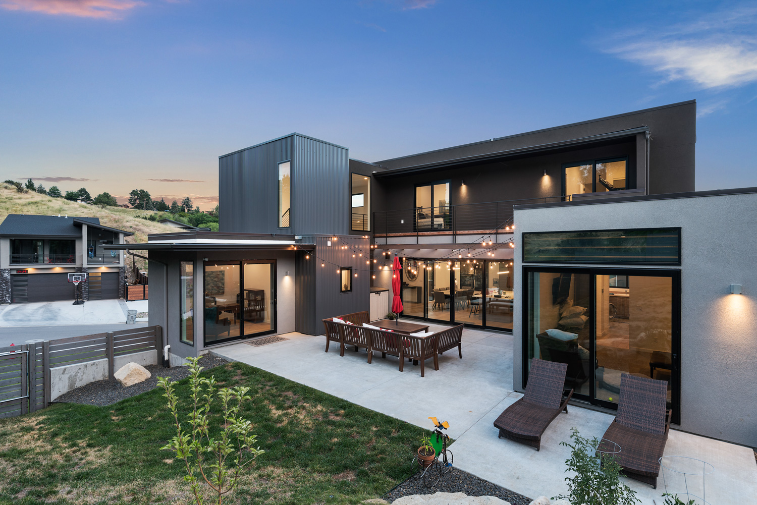 Contemporary luxury home exterior at twilight with large windows and flat roof in Boise Idaho