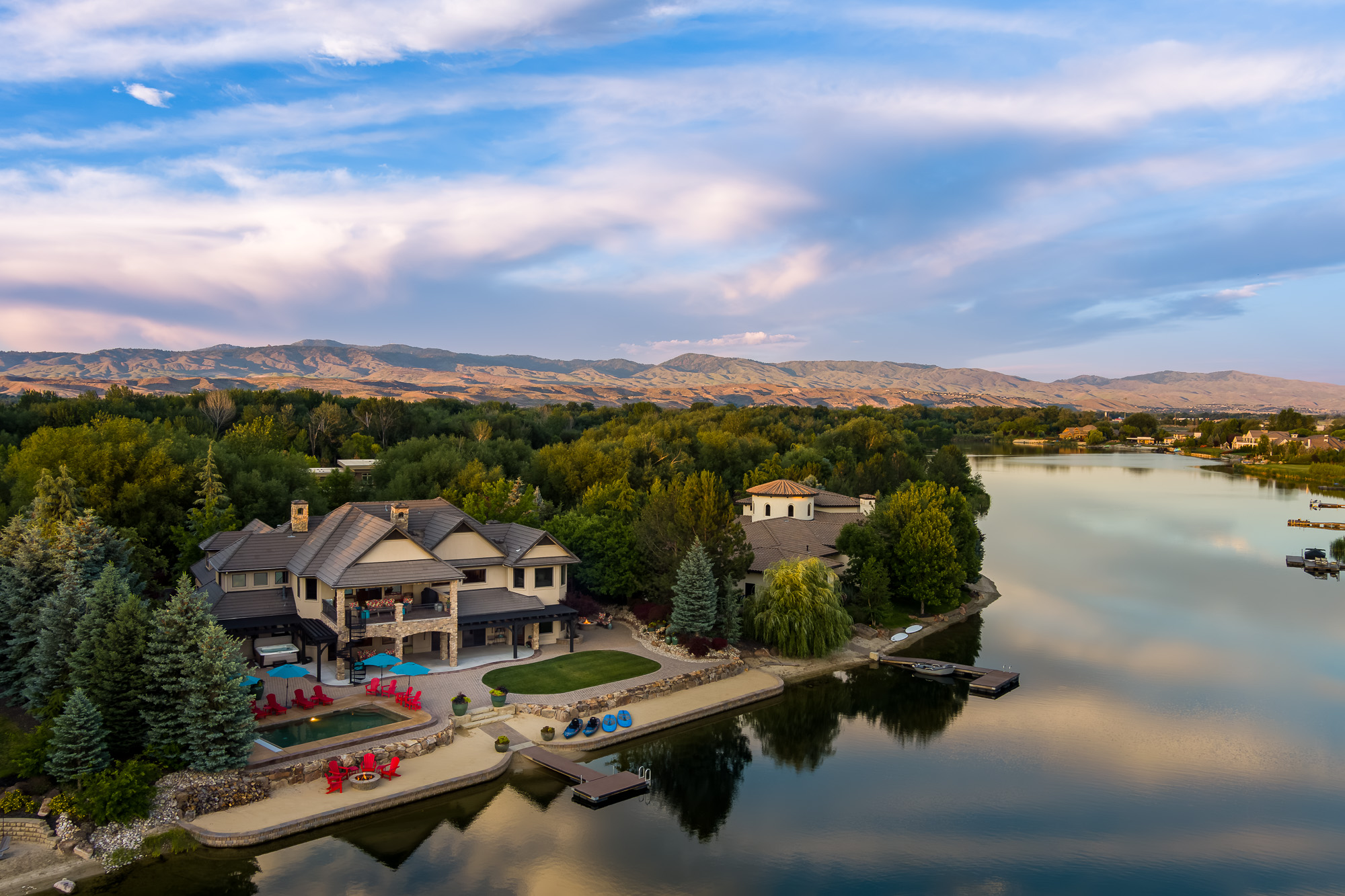 Luxury lakefront estate with pool dock and fire pit area in Idaho foothills