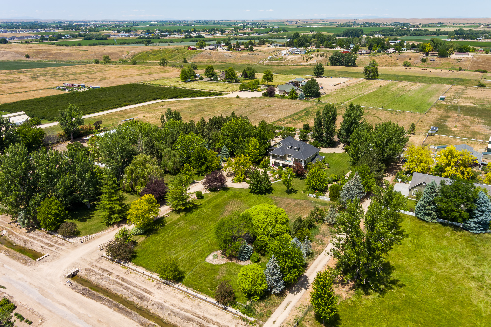 Aerial drone view of rural Idaho country estate with mature trees and farmland