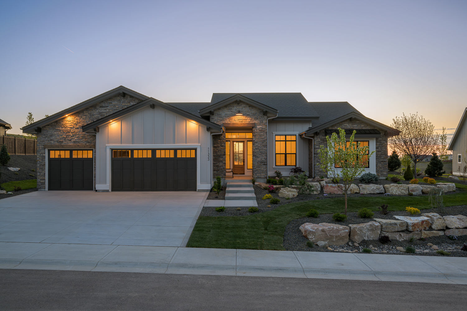 Stunning stone and wood luxury estate exterior at twilight in Eagle Idaho