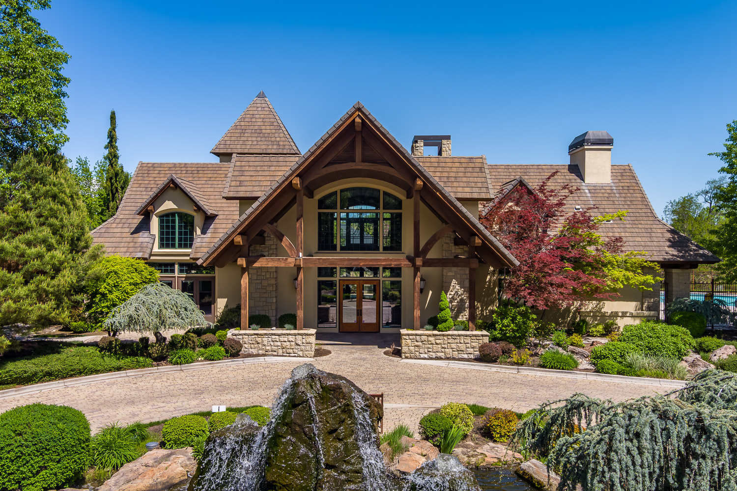 Grand living room with wood beams and stone fireplace in Eagle Idaho luxury home