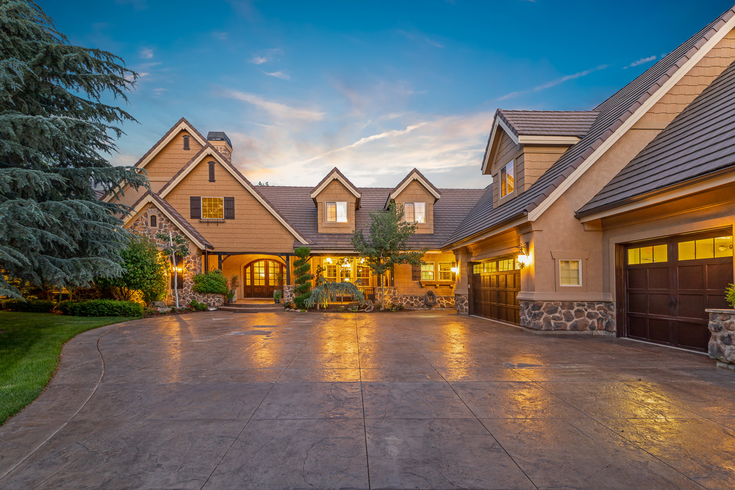 Large custom home with manicured lawn and pool at sunset in Meridian Idaho