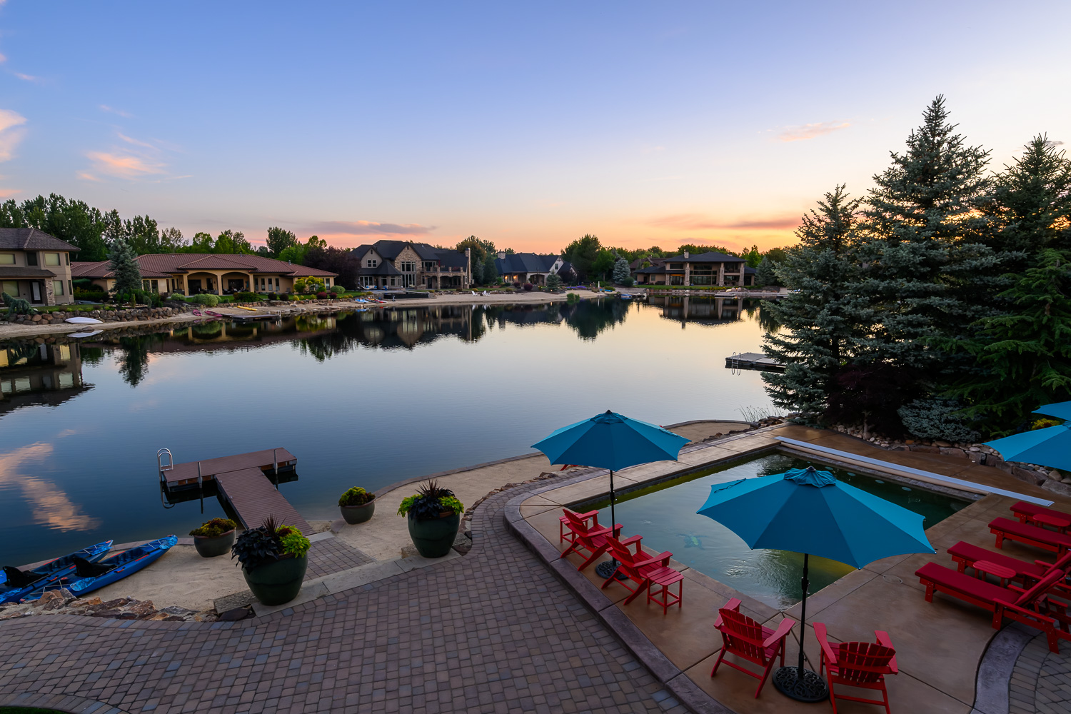 Mixed material luxury home exterior with wood and stone at dusk in Eagle Idaho
