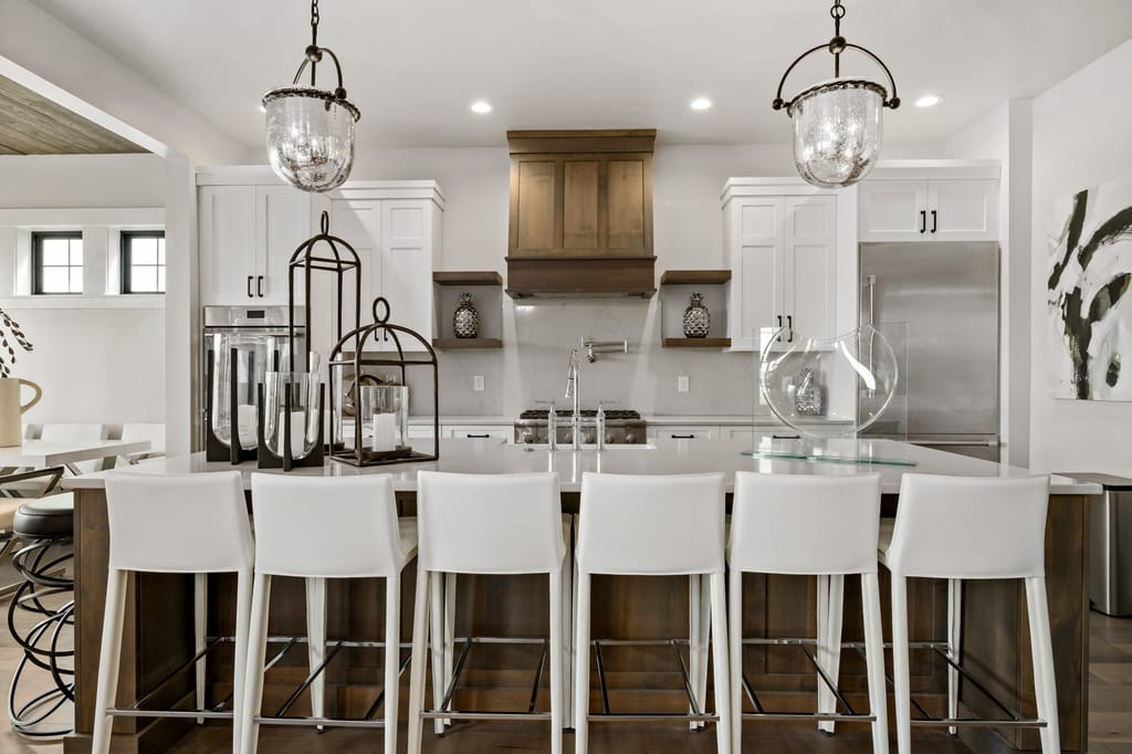 Gourmet kitchen interior with large island, wood range hood, and pendant lighting in Boise Idaho