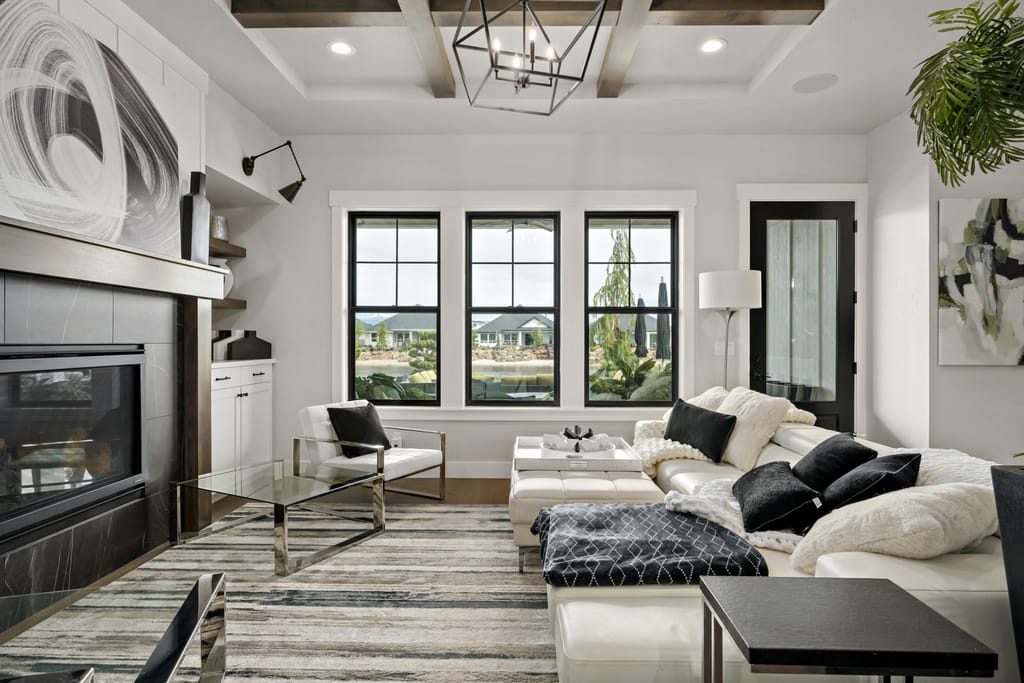 Elegant living room interior with coffered beam ceiling, modern fireplace, and black-framed windows