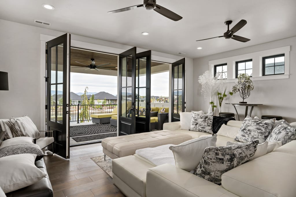 Interior living room with bifold glass doors opening to covered patio with mountain views in Boise