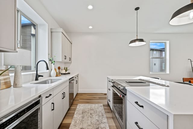 Bright modern kitchen interior with white countertops, island cooktop, and pendant lighting in Boise Idaho