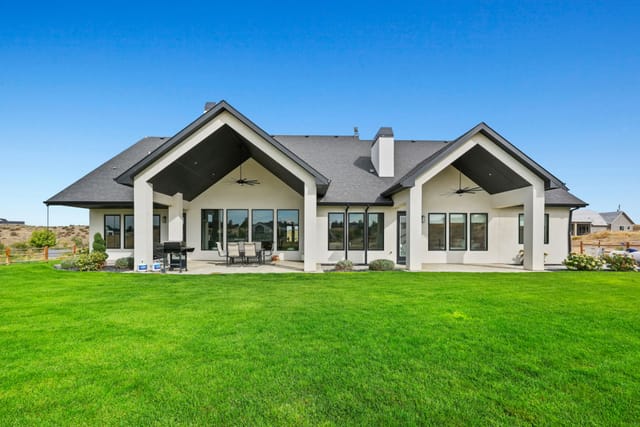 Exterior rear view of Boise Idaho home with covered patio and manicured green lawn