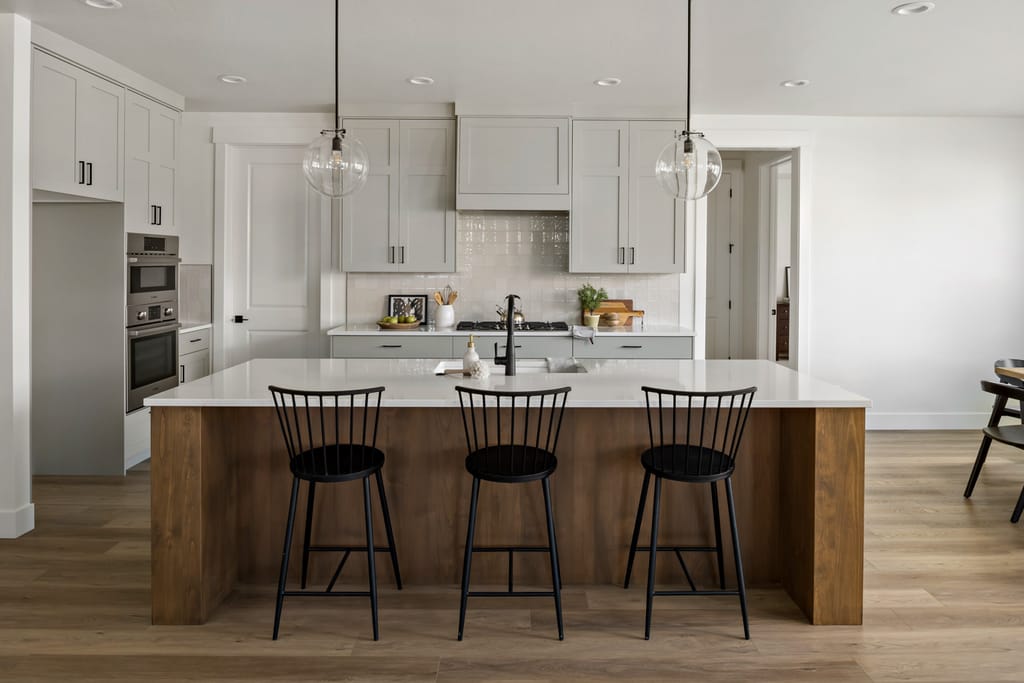 Modern white kitchen with island and bar stools in Boise Idaho new construction home