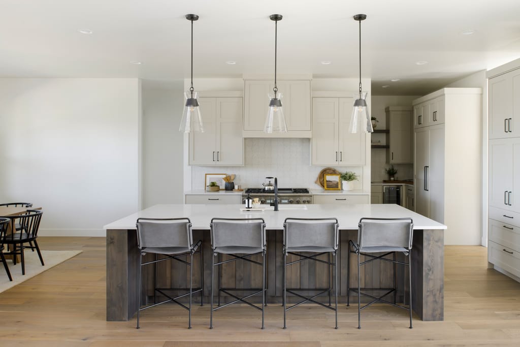 Bright white modern kitchen with waterfall island and pendant lights in Boise Idaho