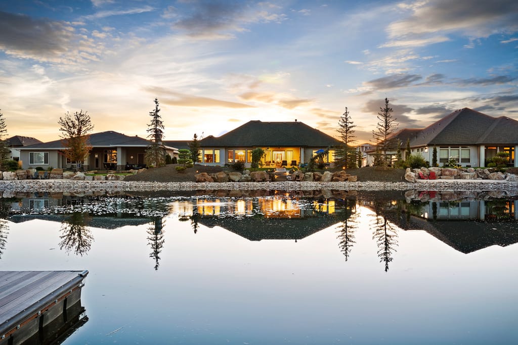 Modern luxury home exterior at dusk with outdoor lighting and mountain views in Boise