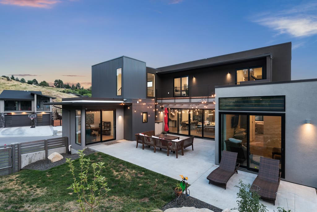 Contemporary luxury home exterior at twilight with large windows and flat roof in Boise Idaho