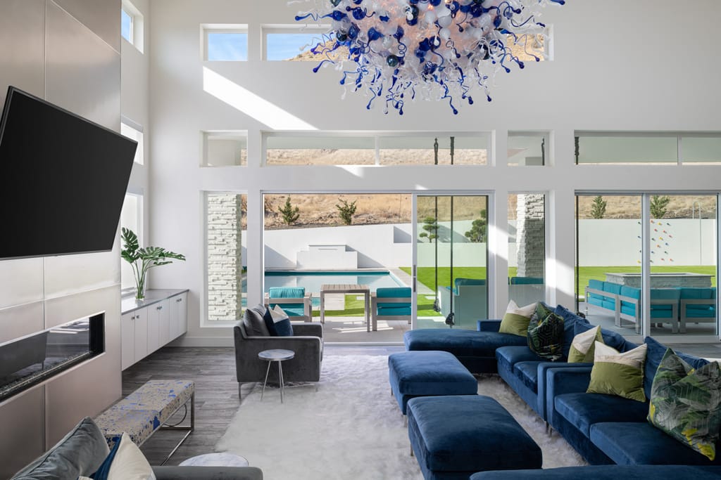 Living room with blue Chihuly-style glass chandelier and dark hardwood floors in Boise