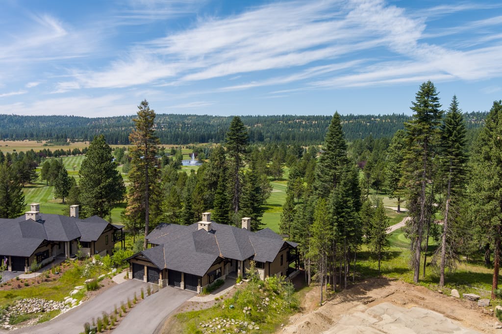 Aerial view of luxury homes among pines overlooking Idaho golf course with fountain