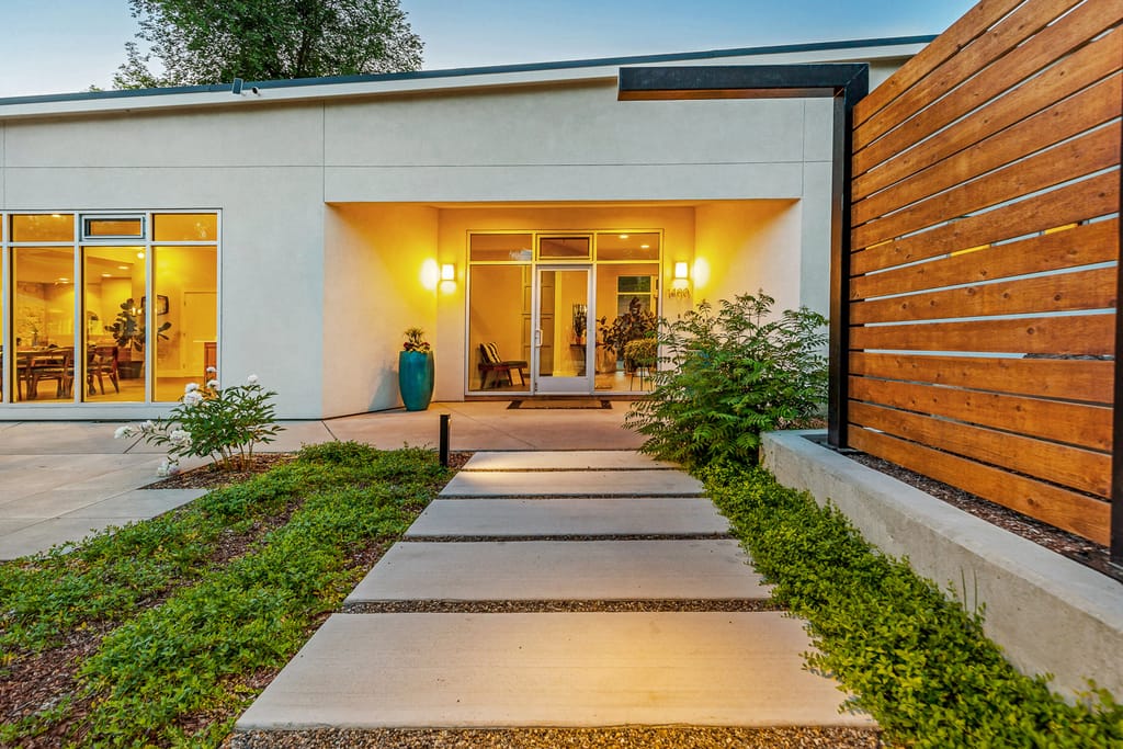 Twilight exterior of modern home with warm entry lighting in Boise Idaho