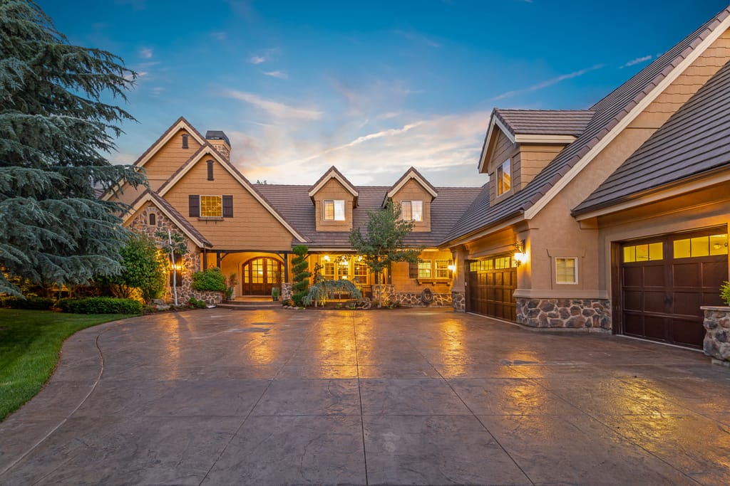 Large custom home with manicured lawn and pool at sunset in Meridian Idaho