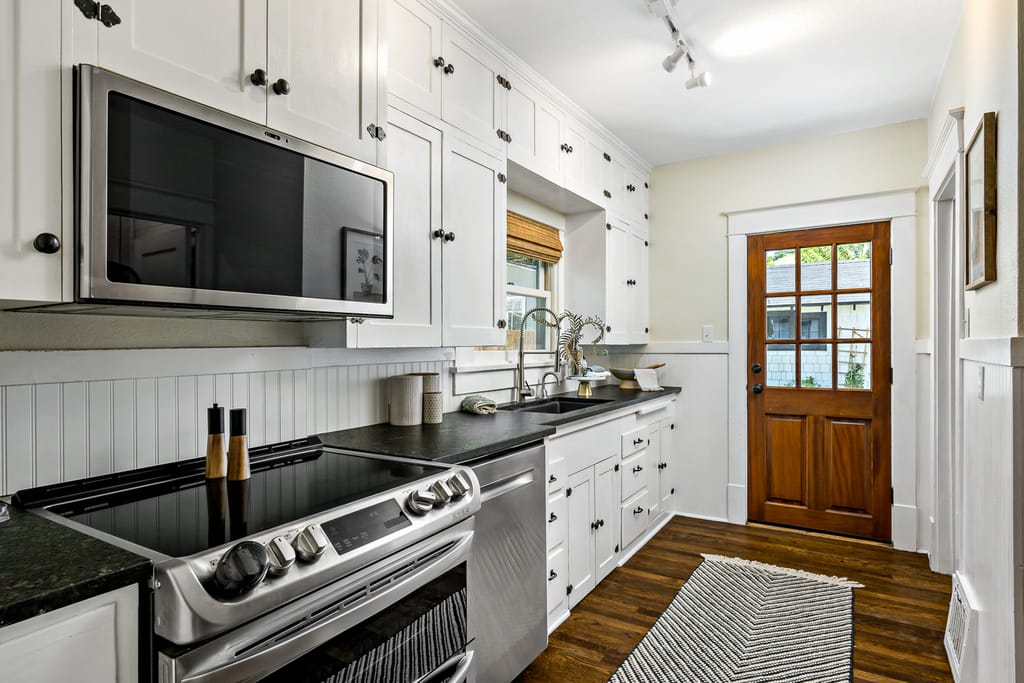 Modern white kitchen with vaulted ceiling and pendant lights in Meridian Idaho