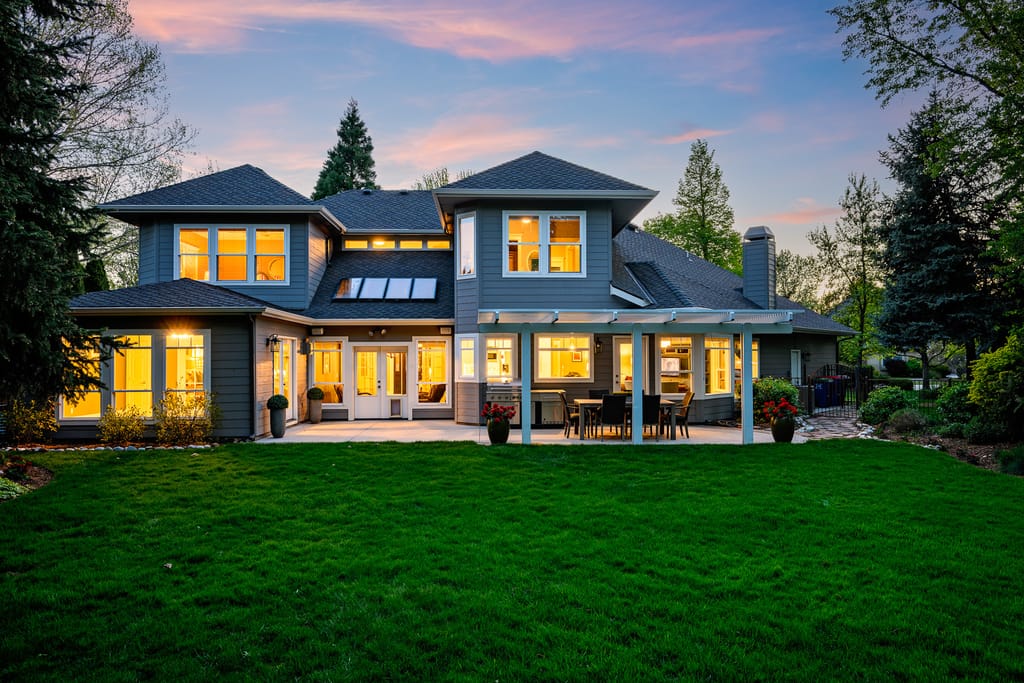 White modern farmhouse exterior with three-car garage at twilight in Meridian Idaho