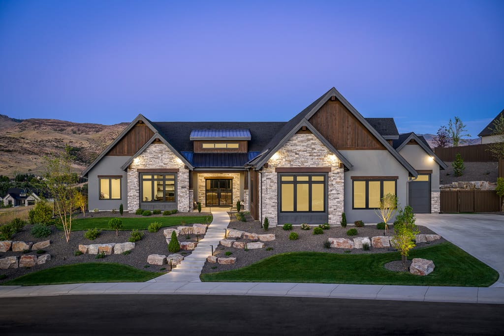 Blue craftsman-style luxury home exterior with landscaped yard at twilight in Eagle Idaho