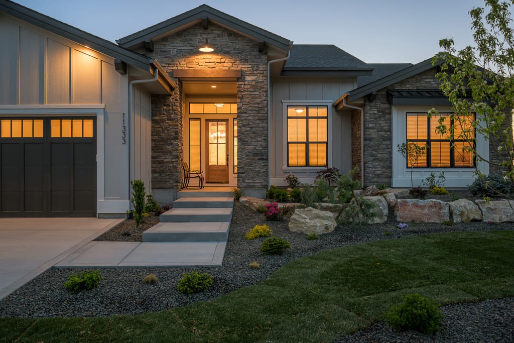 Elegant white exterior of luxury home with arched entry at twilight in Meridian Idaho