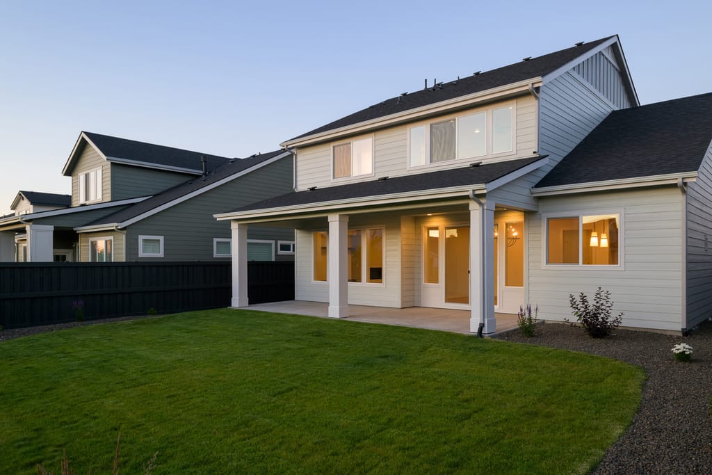 Luxury home exterior with outdoor dining and water feature at twilight in Boise Idaho